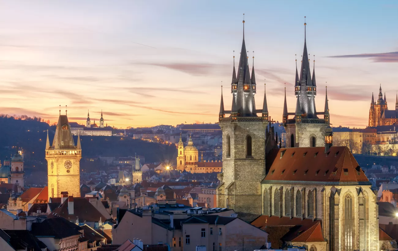 Night falls over the distinctive towers of Prague