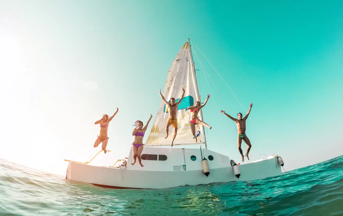 Friends jumping in blue Caribbean waters