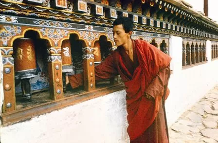 Monk rotating prayer wheel