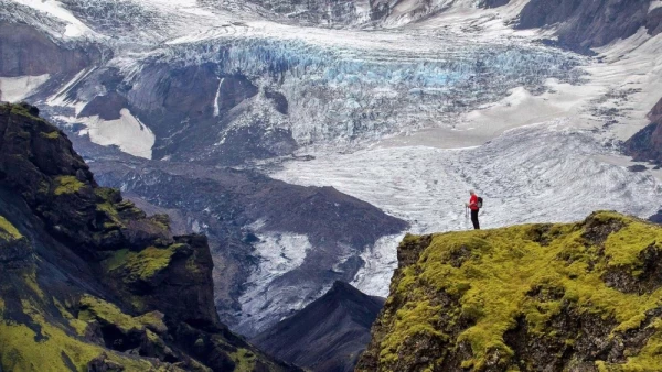 A person in the distance with a glacier in the background