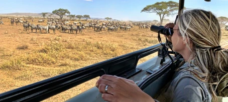 Woman spotting a zebra herd on a South Africa safari