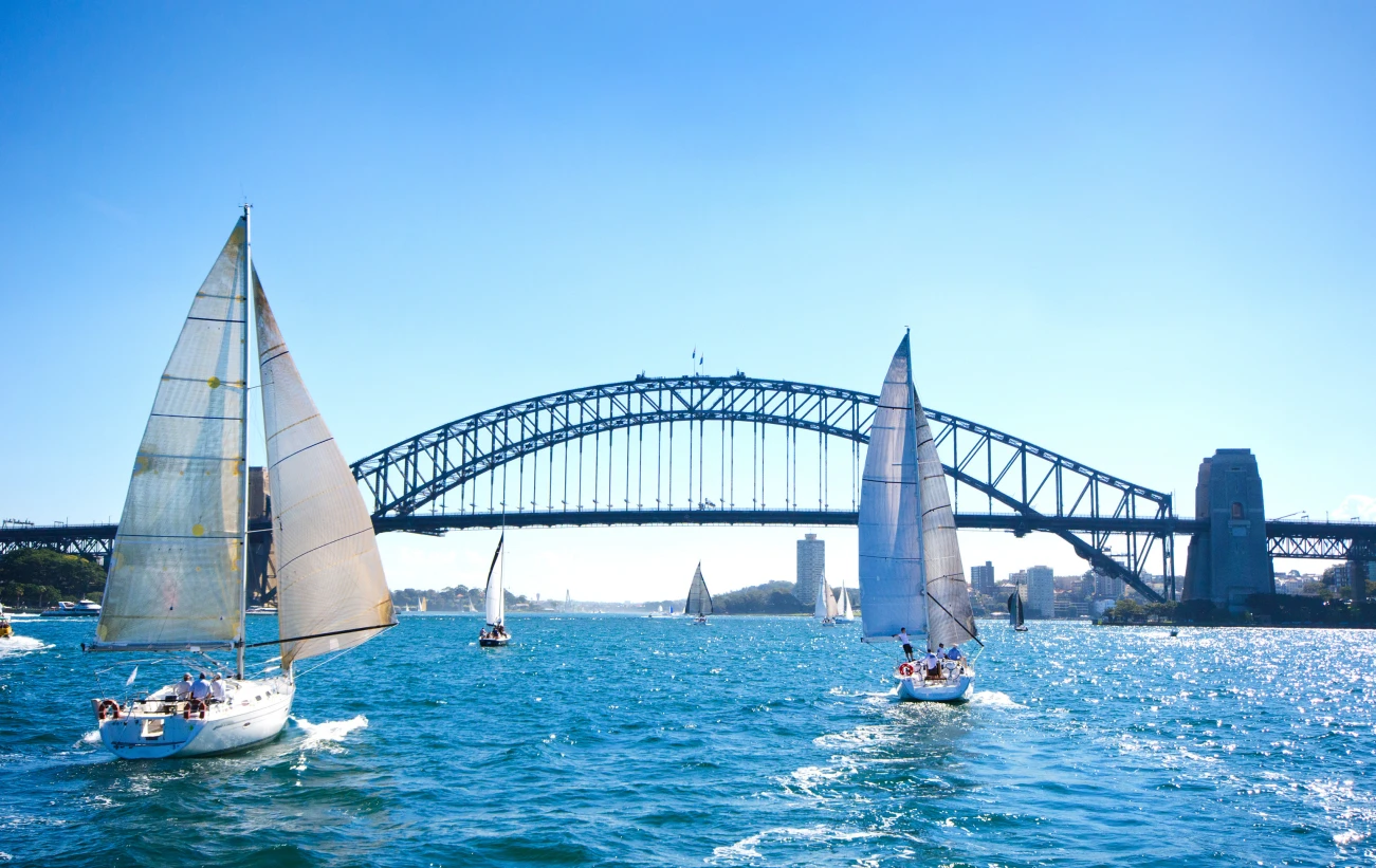 Sailboats on a sunny day at Sydney Harbor, Australia. Iconic Sydney Harbor Bridge in the background.