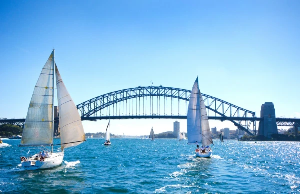Sailboats on a sunny day at Sydney Harbor, Australia. Iconic Sydney Harbor Bridge in the background.