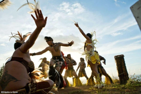 Cultural dancers in traditional attire engage in a vibrant performance outdoors in Ua Pou