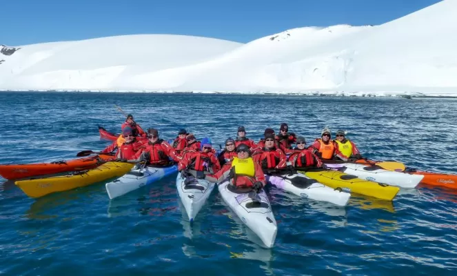 Kayakers pose in formation for the camera.