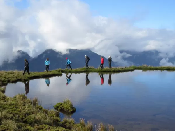 Hikers next to a mountain lake on top of Chile's mountains.