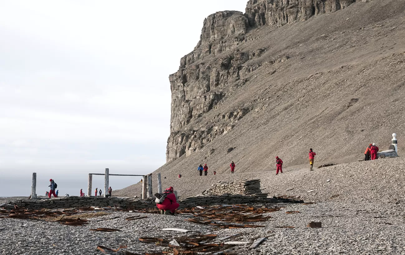 Travelers walking around the arctic landscape.