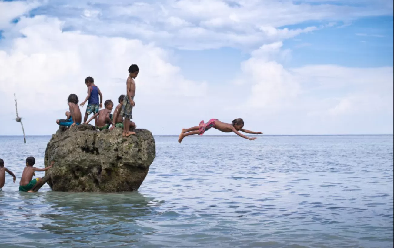 Children dive from the rocks.